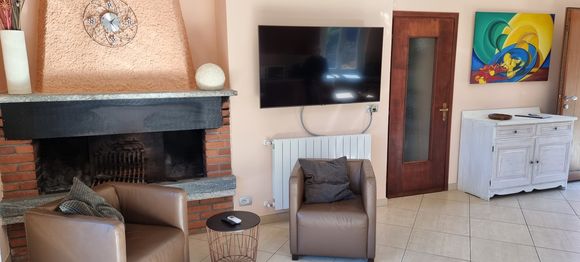 Wohnzimmer mit Kamin und 55" Smart-TV
